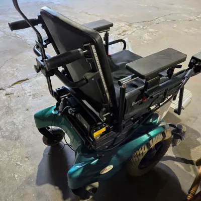 Older Solaire motorized power wheelchair with owner's manual and accessories