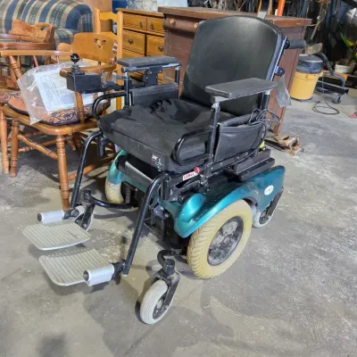 Older Solaire motorized power wheelchair with owner's manual and accessories