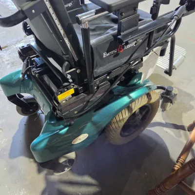 Older Solaire motorized power wheelchair with owner's manual and accessories