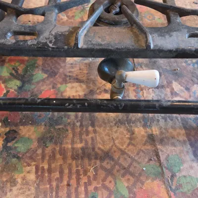 Vintage cast-iron three-burner camp stove with porcelain handles marked 137 on bottom Possibly a Griswold?