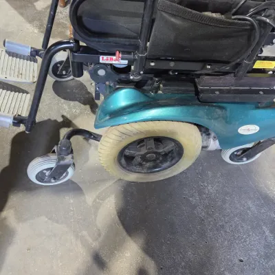 Older Solaire motorized power wheelchair with owner's manual and accessories