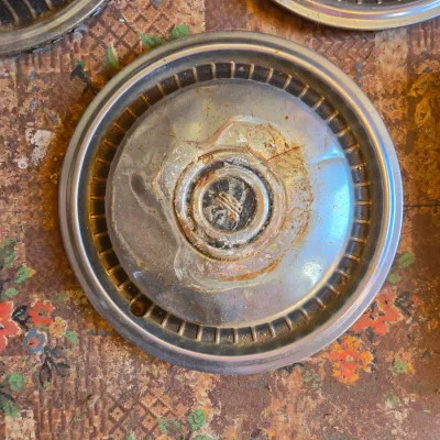 Three vintage chrome hubcaps