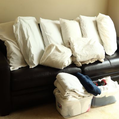 A Collection of Bed Pillows, Linens, and Towels with Two Plastic Storage Bins