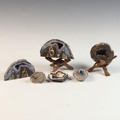A Collection of Amethyst and Agate Geode Specimens with Carved Wood Stands
