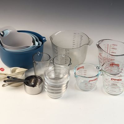 A Collection of Kitchen Mixing Bowls and Measuring Tools Including Pyrex Glass Cups