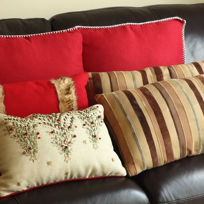 A Collection of Six Decorative Throw Pillows in Red, Cream, and Striped Patterns