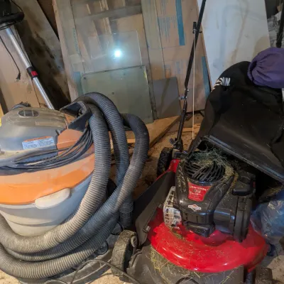 Sale Photo Thumbnail #97: Craftsman walk-behind lawn mower with a Briggs & Stratton engine, shown alongside a Ridgid wet/dry shop vacuum with a wrapped hose.
