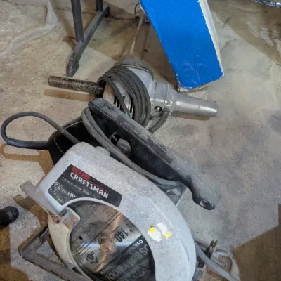 Sale Photo Thumbnail #98: Vintage Sears Craftsman 7 1/4-inch circular saw with a 2 1/8 HP motor, showing signs of use, alongside a vintage power drill.