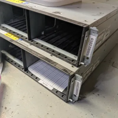Sale Photo Thumbnail #110: Two stacked rackmount server chassis, showing empty drive bays and labeled mounting brackets.