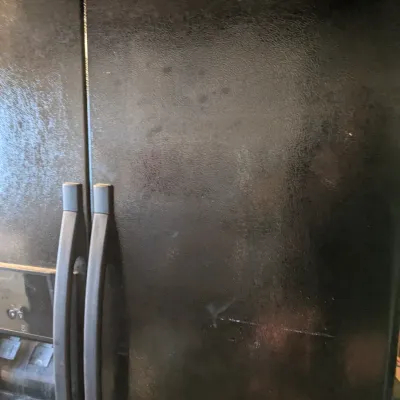 Sale Photo Thumbnail #100: Whirlpool side-by-side refrigerator in a textured black finish, featuring an external ice and water dispenser.