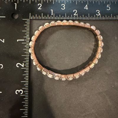 copper-toned stretch bracelet featuring a continuous line of bezel-set, milky cabochon stones. Type