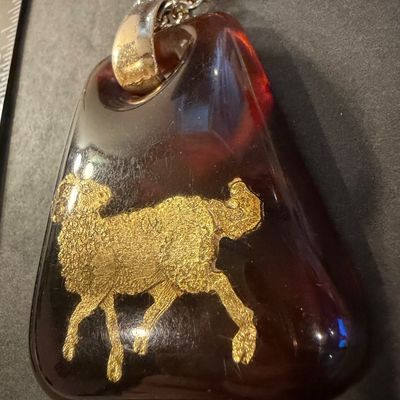 vintage 1970s Helena Rubinstein Aries zodiac pendant necklace featuring a brown tortoise lucite body with an inlaid gold-tone ram symbol