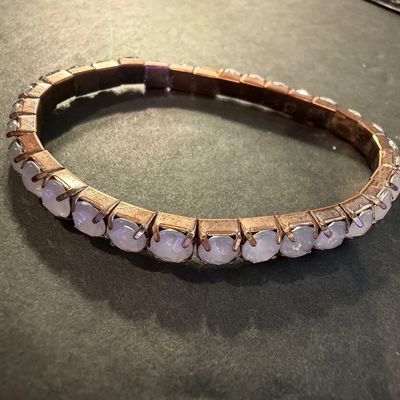 copper-toned stretch bracelet featuring a continuous line of bezel-set, milky cabochon stones. Type
