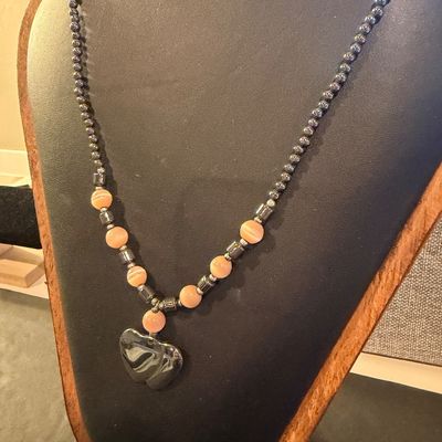 Vintage beaded necklace featuring metallic gray hematite beads and peach cat's-eye glass beads accented with a heart-shaped pendant.