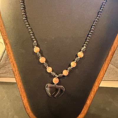 Vintage beaded necklace featuring metallic gray hematite beads and peach cat's-eye glass beads accented with a heart-shaped pendant.