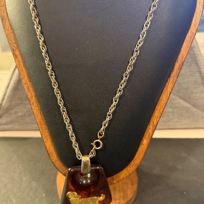 vintage 1970s Helena Rubinstein Aries zodiac pendant necklace featuring a brown tortoise lucite body with an inlaid gold-tone ram symbol