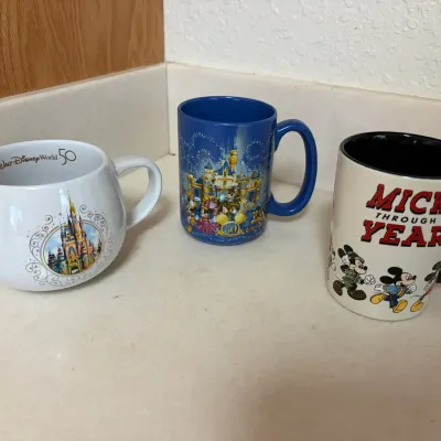 Three Disney-Themed Ceramic Mugs Featuring Various Designs