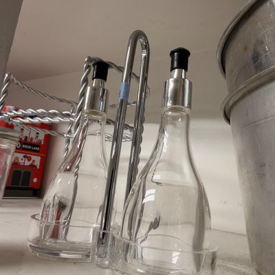 Glass oil and vinegar cruets in chrome caddy