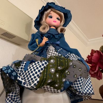 Vintage big-eye doll in blue bonnet, patchwork dress