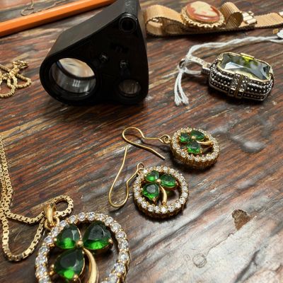 Green rhinestone pendant and earrings, jeweler's loupe