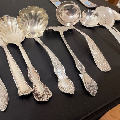 Ornate sterling silver serving spoons and shell ladles