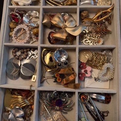 Vintage brooches and costume jewelry in tray