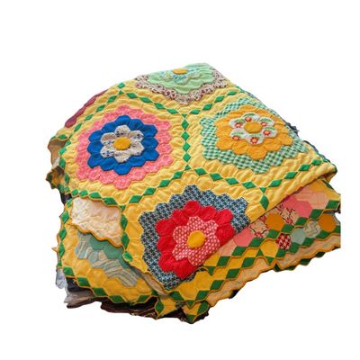 Vintage handmade hexagonal patchwork quilt featuring a classic "Grandmother's Flower Garden" floral design set against...