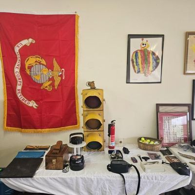 Vintage yellow three-light traffic signal, a retired U.S. Marine Corps flag with gold fringe, and various framed artwork and collectibles...