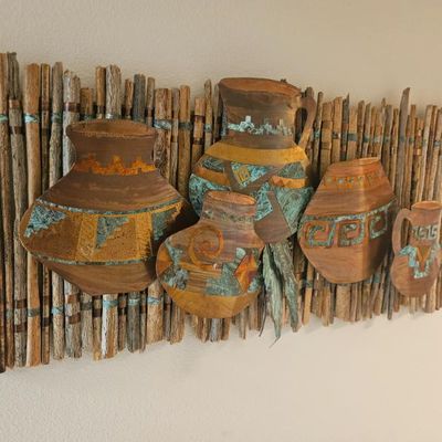 Southwestern-style mixed media wall art featuring copper and verdigris pottery silhouettes mounted on a rustic twig backing.