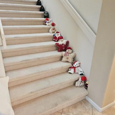 Collection of holiday-themed plush toys, including Ty Beanie Babies and star-shaped pillows,