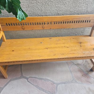 Rustic wooden bench with a decorative cutout backrest,