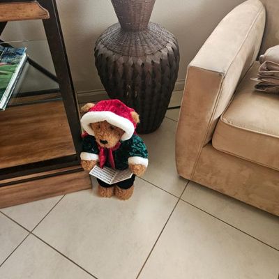 Large woven wicker floor vase in a dark brown finish, shown alongside a plush Christmas carolling teddy bear figure.