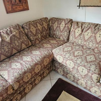 L-shaped sectional sofa featuring a Southwestern-style geometric pattern in earth tones of brown, tan, and cream.