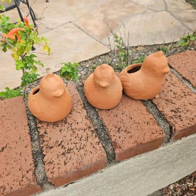 Trio of small terracotta bird planters, ideal for succulents or garden decor.
