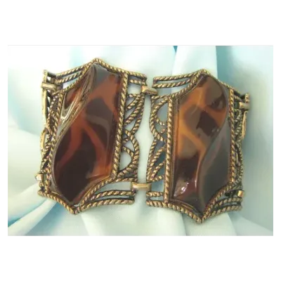 Sale Photo Thumbnail #6: Retro Faux Tortoiseshell Lucite Bracelet
7.5” long
Wonderful very wide 4 section bracelet featuring bold swirl lucite faux tortoise set in bronze tone metal. The bracelet is finished with a foldover clasp.

The bracelet is 2-1/4" wide by 7-1/2" wide. Be