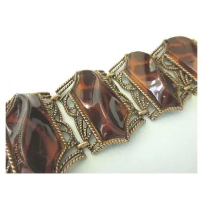 Sale Photo Thumbnail #5: Retro Faux Tortoiseshell Lucite Bracelet
7.5” long
Wonderful very wide 4 section bracelet featuring bold swirl lucite faux tortoise set in bronze tone metal. The bracelet is finished with a foldover clasp.

The bracelet is 2-1/4" wide by 7-1/2" wide. Be