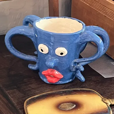 Whimsical hand-sculpted blue ceramic mug