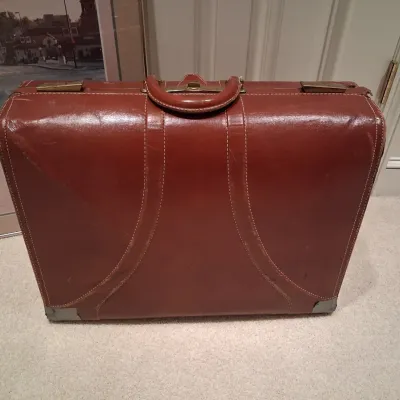 LEATHER SUITCASE AND SIGNED POSTER "PLAZA DAWN"