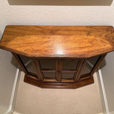 WOODEN LIGHTED LOW CABINET WITH MULTI-PANE GLASS DOUBLE DOORS AND A BEAUTIFUL RECTANGULAR WOOD FRAMED WALL MIRROR ACCENTED WITH ORNATE...