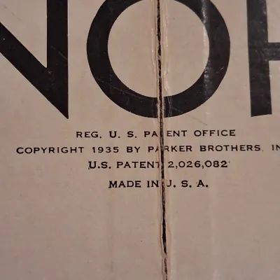 1935 MONOPOLY GAME AND ANTE-UP-RUMMY BOARD WITH MARBLES STORED IN THE FRAME PLUS PLAYING CARDS