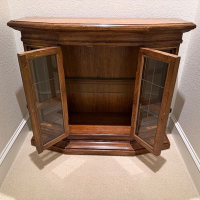 WOODEN LIGHTED LOW CABINET WITH MULTI-PANE GLASS DOUBLE DOORS AND A BEAUTIFUL RECTANGULAR WOOD FRAMED WALL MIRROR ACCENTED WITH ORNATE...