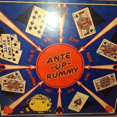 1935 MONOPOLY GAME AND ANTE-UP-RUMMY BOARD WITH MARBLES STORED IN THE FRAME PLUS PLAYING CARDS