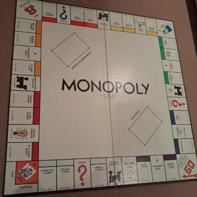 1935 MONOPOLY GAME AND ANTE-UP-RUMMY BOARD WITH MARBLES STORED IN THE FRAME PLUS PLAYING CARDS