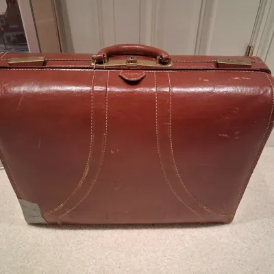 LEATHER SUITCASE AND SIGNED POSTER "PLAZA DAWN"
