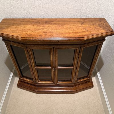 WOODEN LIGHTED LOW CABINET WITH MULTI-PANE GLASS DOUBLE DOORS AND A BEAUTIFUL RECTANGULAR WOOD FRAMED WALL MIRROR ACCENTED WITH ORNATE...