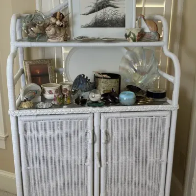 White Wicker Cabinet with Framed Art and Home Accents