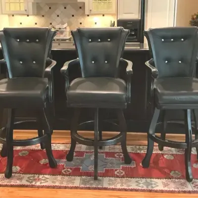 Three Black Upholstered Swivel Bar Stools With Rug