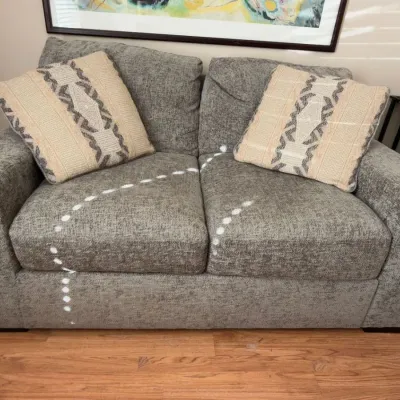 Gray upholstered loveseat with throw pillows