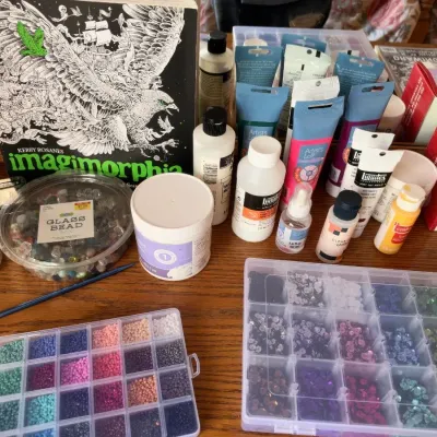 Craft supplies, beads in organizers, acrylic paints, Imagimorphia coloring book
