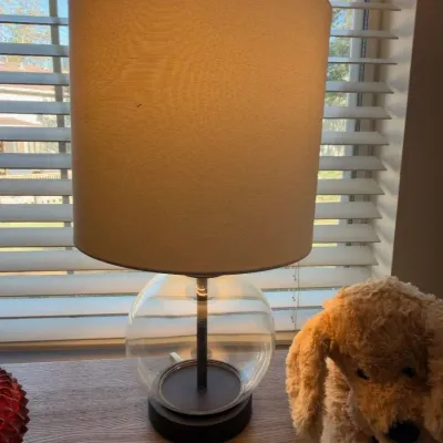 Clear glass globe table lamp with drum shade, plush puppy